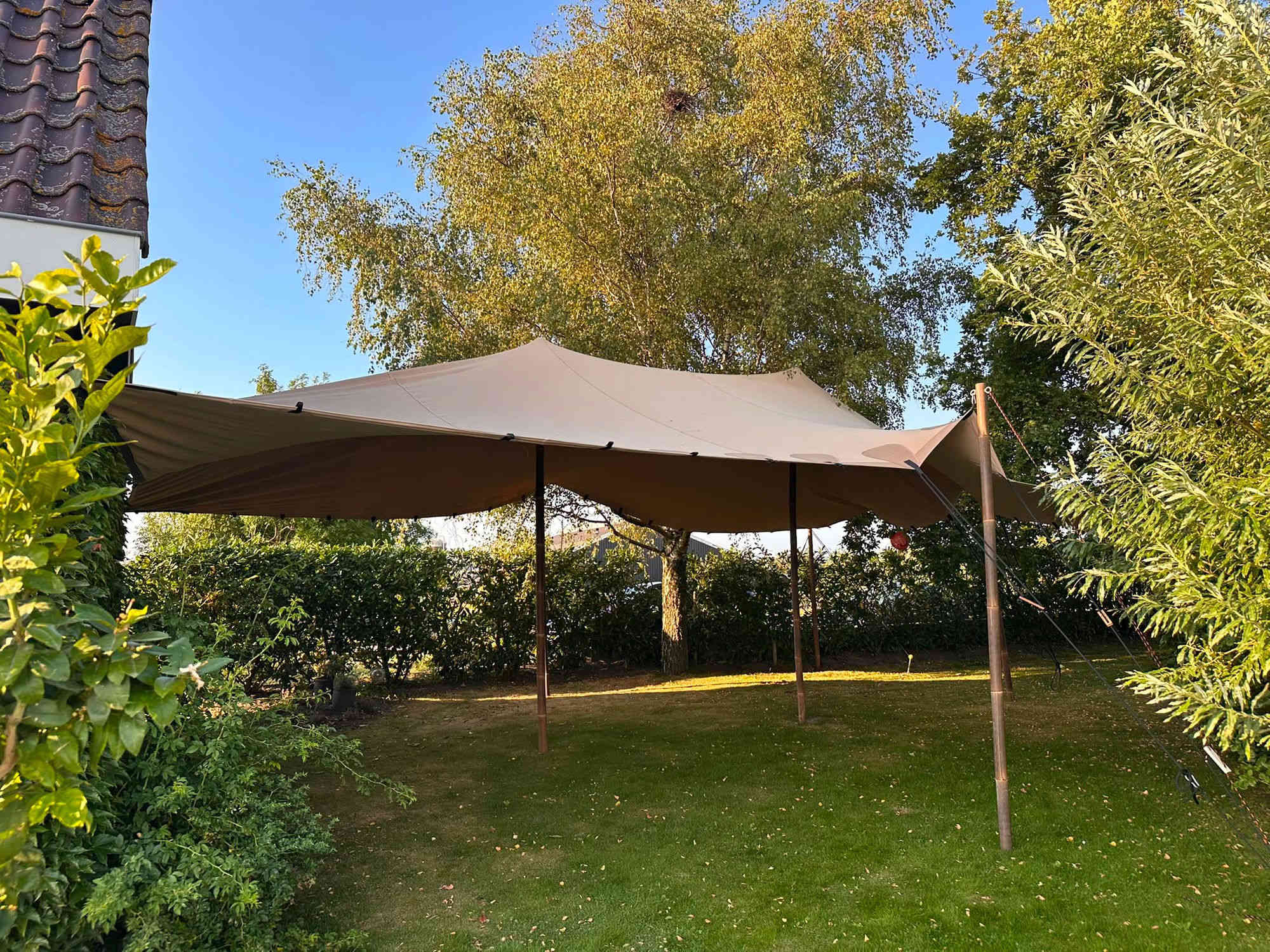Beige stretchtent in een tuin